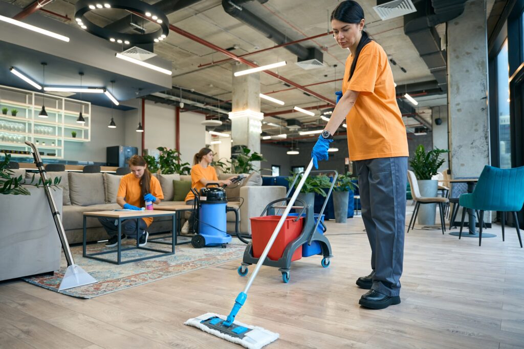 Employees cleaning company performs general cleaning of a coworking space