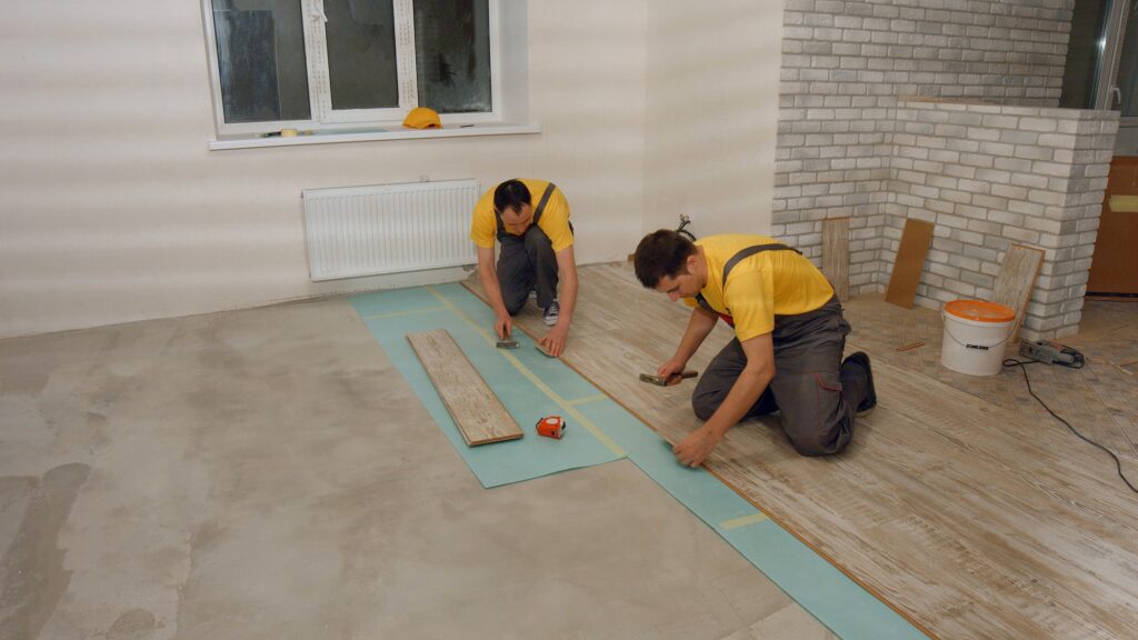 Builders laying wooden flooring. Building, construction and peple. Home repair concept.